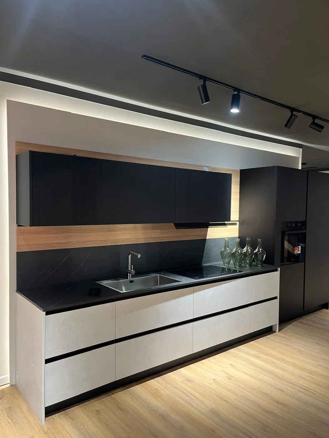 Cucina lineare bianca e nera con inserto in legno e piano in marmo, montata da Cr Montaggi
