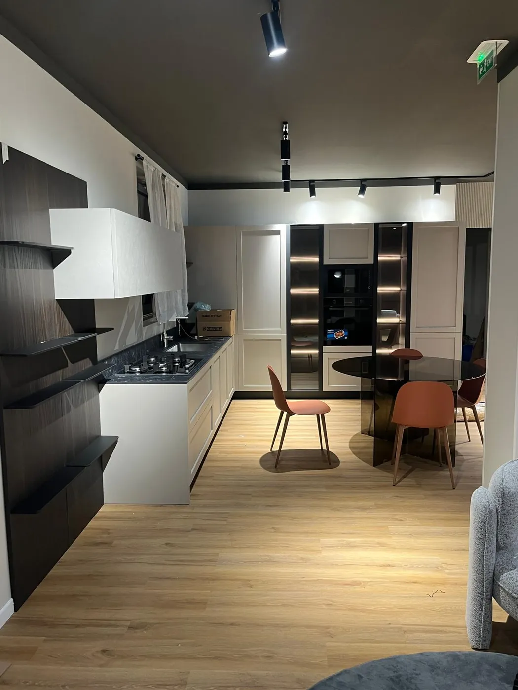 Cucina bianca con libreria a giorno nera e zona pranzo
